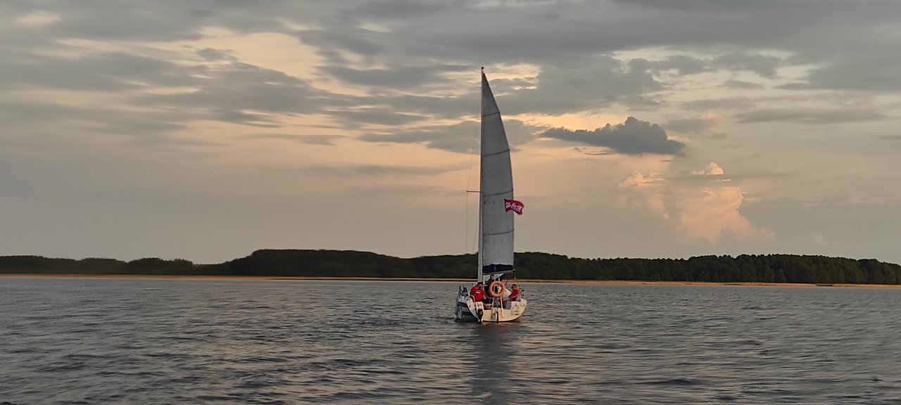 Żagle BBA 2020 - jacht pod banderą BBA płynący pośrodku jeziora
